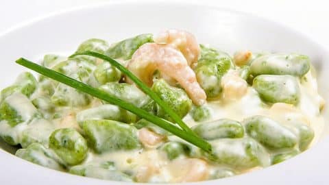 Spinach gnocchi with shrimps in cheese sauce